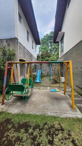 a playground in a yard next to a building at Summer Hills Hotel & Villas Bandung in Bandung