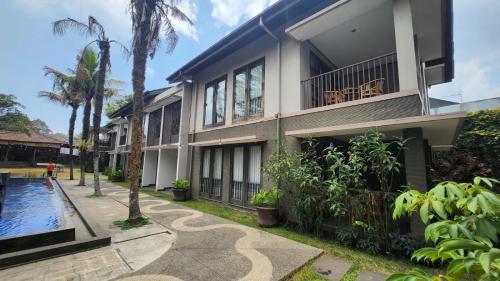 a house with a swimming pool in front of it at Summer Hills Hotel & Villas Bandung in Bandung