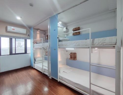 a room with two bunk beds and a hallway at Onederz Hostel Hangzhou in Hangzhou