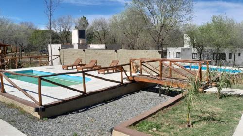 una piscina con una terraza con sillas junto a ella en Cabañas Samay, en Casa Grande