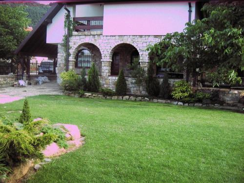 a house with a green yard with a building at Villa Serz in Bitola