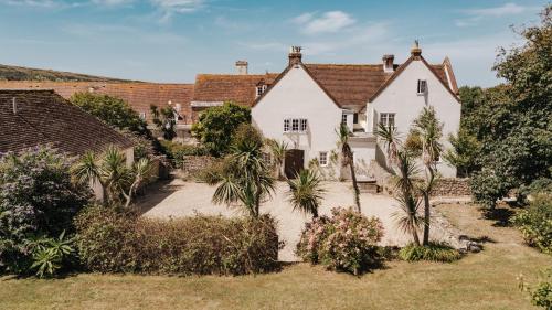 a white house with palm trees in the yard at Tapnell Manor At Tapnell Farm in Yarmouth