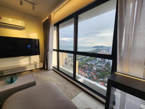 a living room with a large window with a view at Urban Suite - George Town in Jelutong