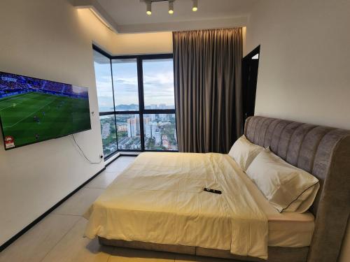 a bedroom with a bed and a tv and a couch at Urban Suite - George Town in Jelutong