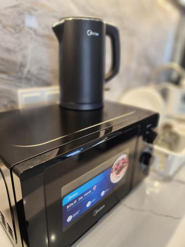 a coffee pot sitting on top of a toaster oven at Urban Suite - George Town in Jelutong