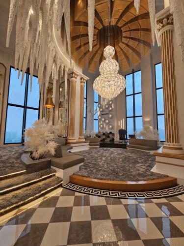 a lobby with a chandelier and a checkerboard floor at Arte Cheras The Premium Suites by iLuxHome in Kuala Lumpur