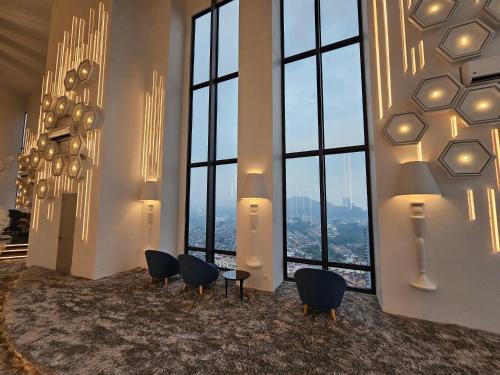 a room with chairs and windows with a view at Arte Cheras The Premium Suites by iLuxHome in Kuala Lumpur