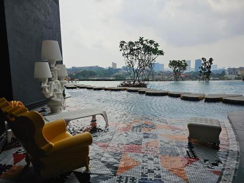 a room with chairs and a pool of water at Arte Cheras The Premium Suites by iLuxHome in Kuala Lumpur
