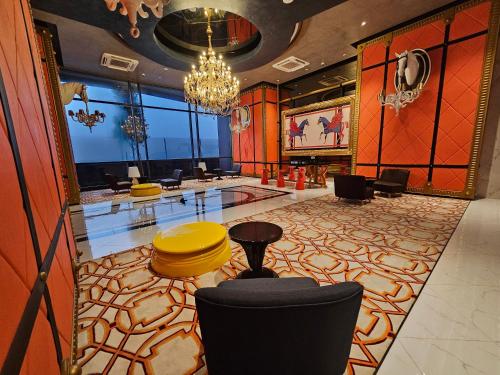 a lobby with a chandelier and tables and chairs at Arte Cheras The Premium Suites by iLuxHome in Kuala Lumpur