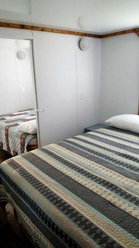 a bedroom with a bed with a striped blanket at Old Wooden Bridge Resort & Marina in Big Pine Key