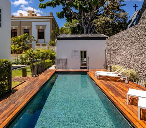 une piscine avec une terrasse en bois et une maison dans l'établissement The Park Suites, à Santa Cruz de Tenerife