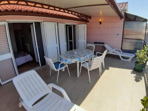 a patio with a table and chairs on a balcony at Guesthouse Brodarica (3814) in &Scaron;ibenik