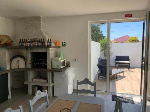 a living room with a fireplace and a view of a patio at Oliver Beach House in Poço da Cruz