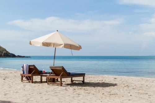 zwei Stühle und ein Sonnenschirm am Strand in der Unterkunft Anda Lanta Resort in Ko Lanta