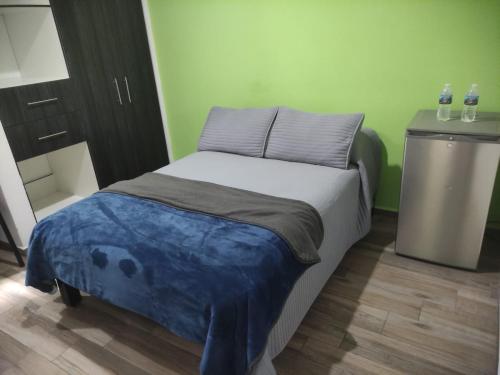 - un petit lit dans une chambre avec 2 bouteilles d'eau dans l'établissement Casa el 9, à Querétaro