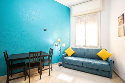 ein blaues Wohnzimmer mit einem Sofa und einem Tisch in der Unterkunft SAN MARCO 13 l t in Neapel