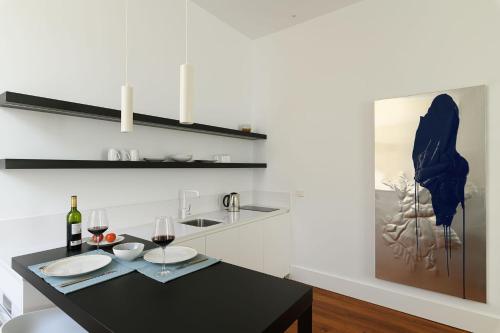 eine Küche mit einem schwarzen Tisch und Gläsern Wein in der Unterkunft The Park Suites by IRES LAR in Santa Cruz de Tenerife