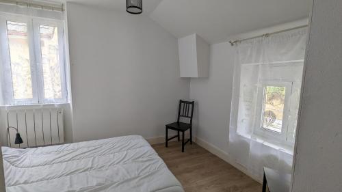 ein Schlafzimmer mit einem Bett und einem Stuhl und einem Fenster in der Unterkunft Chez Thythy in Savignac-les-Ormeaux