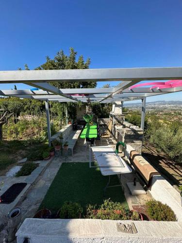 a group of picnic tables and benches under a canopy at Archontiko Alexandros Luxury Suites in Kardiá
