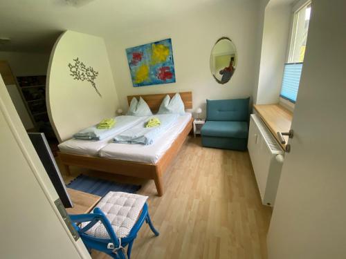ein Schlafzimmer mit einem Bett, einem Stuhl und einem Spiegel in der Unterkunft Family Appartment - Dachstein View in Ramsau am Dachstein