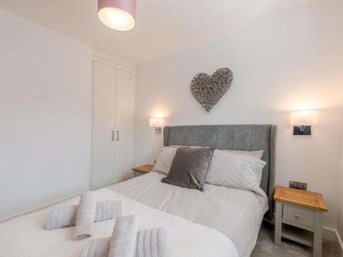 ein Schlafzimmer mit einem Bett mit einem Herz an der Wand in der Unterkunft Pass the Keys 1 bed Albury Contemporary Apartment with Secure Parking in Shrewsbury