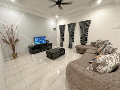 a living room with a couch and a tv at First Curve Ipoh Homestay in Ipoh