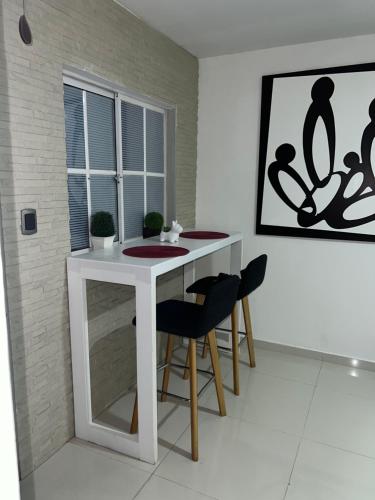 una mesa blanca y sillas en una habitación en Apartaestudio Barranquilla Recreo, primer piso, en Barranquilla