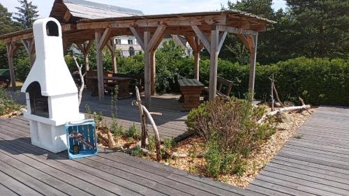 um deque de madeira com um gazebo num jardim em Ferienwohnung Gnitzer Auszeit em Lütow