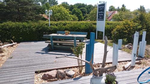 einem Picknicktisch auf einer Holzterrasse mit einem Schild in der Unterkunft Ferienwohnung Gnitzer Auszeit in Lütow