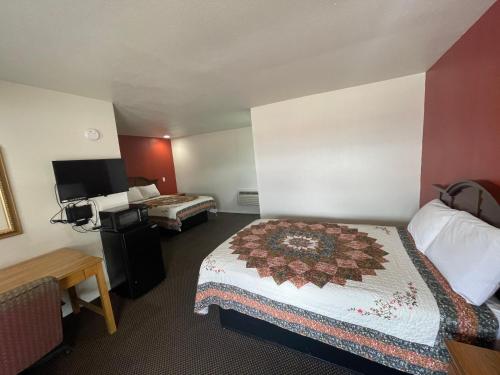 a hotel room with two beds and a desk at Red River Inn 