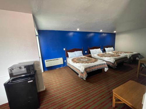 a hotel room with two beds and a blue wall at Red River Inn 