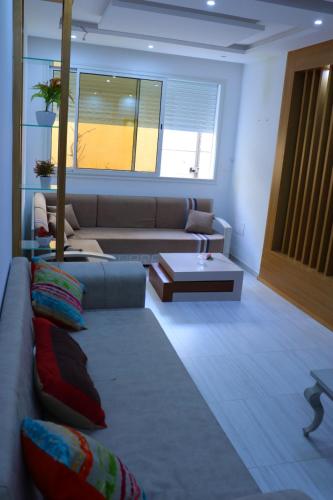 a living room with a couch and a table at séjournez auprès de toutes les commodités in Sousse