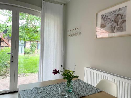 a dining room with a table with a vase of flowers at Ferienwohnung DREI Hof Himmelgrün in Saal