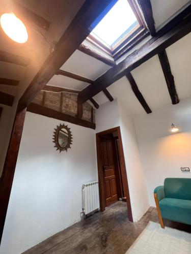 a living room with a skylight and a blue couch at Casa Rural Basiver - Habitación Braña de Los Tejos in Armaño