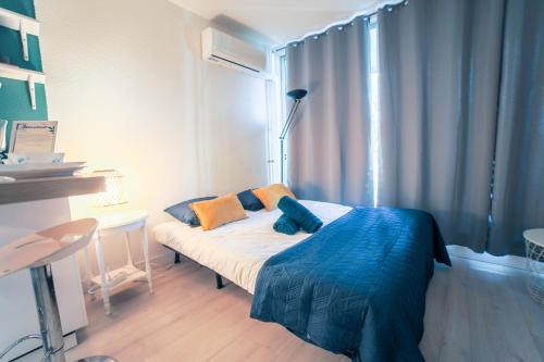 - une chambre avec un lit doté d'oreillers bleus et oranges dans l'établissement L'Épicentre - Clim - Vu sur port- Terrasse -Plage TOP PROS SERVICES, à La Grande Motte