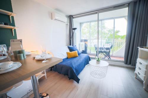 une chambre avec un lit, une table et une fenêtre dans l'établissement L'Épicentre - Clim - Vu sur port- Terrasse -Plage TOP PROS SERVICES, à La Grande Motte