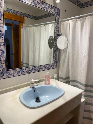 y baño con lavabo y espejo. en Villa Luz Deluxe, en Mazagón