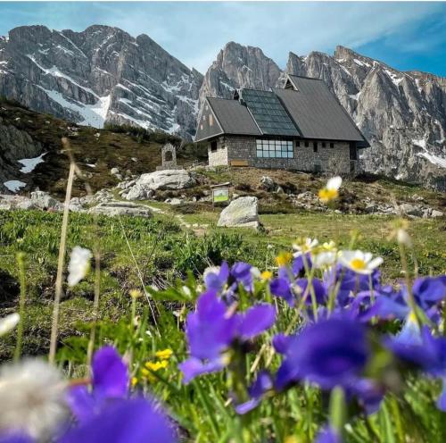 a house on top of a mountain with purple flowers at Casa dell’Annunziata in Chiusa di Pesio