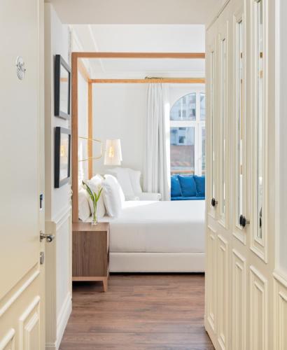 a bedroom with a white bed and a window at H10 Duque de Loule in Lisbon