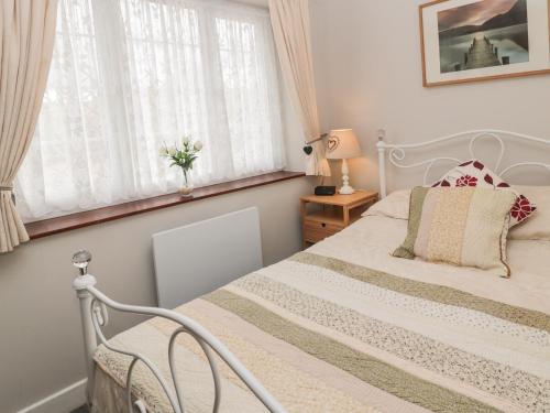 1 dormitorio con cama blanca y ventana en Goldfinch en Grindon