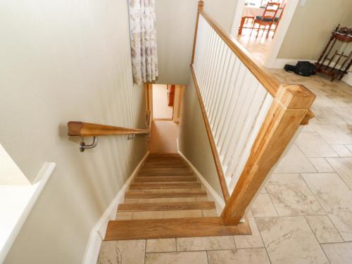 a staircase with wooden railings and a tile floor at Ocean View in Adrigole