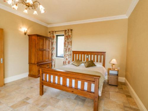 a bedroom with a wooden bed and a window at Ocean View in Adrigole