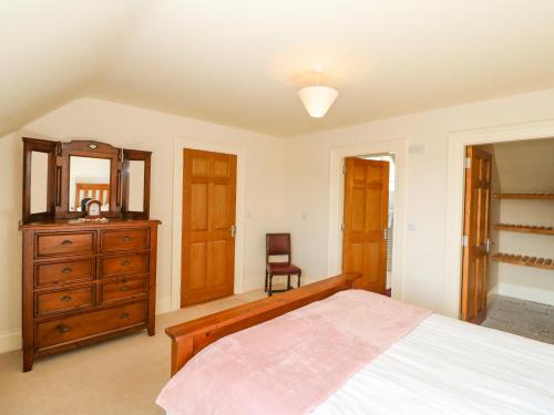 a bedroom with a bed and a dresser and a mirror at Ocean View in Adrigole