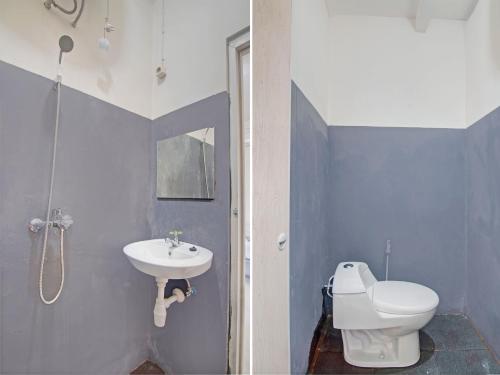 ein Badezimmer mit einem weißen WC und einem Waschbecken in der Unterkunft OYO 92964 Kost 99 in Manado