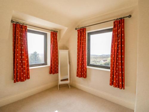 a room with two windows with red curtains at Ocean View in Adrigole