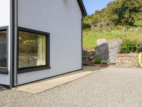 a white building with a large window on the side of it at Ocean View in Adrigole