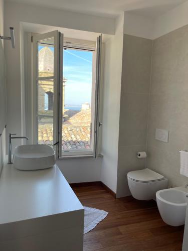 a bathroom with two sinks and a toilet and a window at B&B Aganita in Ancona