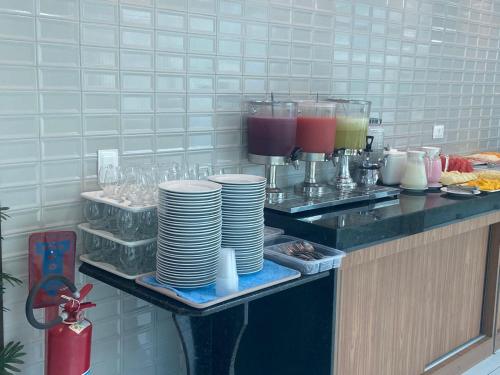 a counter with a bunch of plates and drinks at Pousada Sky Beach Flat in Porto De Galinhas
