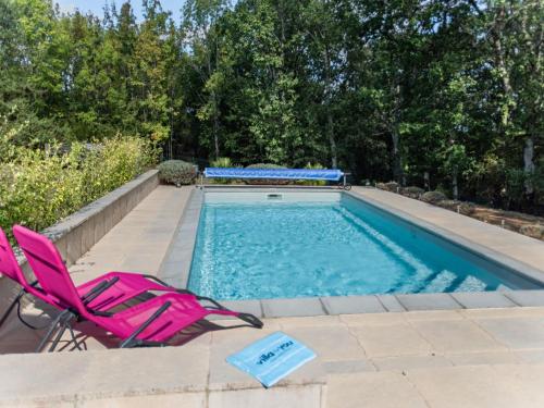 une paire de chaises roses et une piscine dans l'établissement Bellegarde, à Belaye