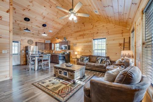 a living room with leather furniture and a ceiling fan at Paws in the Air in Pigeon Forge